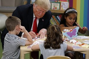 President Donald Trump colors during a visit with a group of children at the Nationwide Children's Hospital, Friday, Aug. 24, 2018, in Columbus, Ohio.