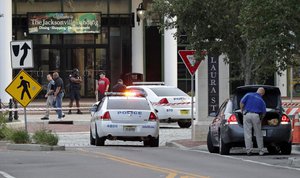 Police cars block off a street near the scene of a mass shooting as law enforcement investigators work on the area at Jacksonville Landing in Jacksonville, Fla., Sunday, Aug. 26, 2018.