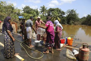 Residents wash household goods after salvaging them from sludge and muck accumulated inside their flood affected houses on the outskirts of Kochi in the southern state of Kerala, India, Tuesday, Aug. 21, 2018.