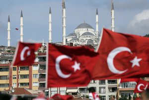 People carry Turkish flags they walk towards the July 15 Martyr's bridge on a "National Unity March" to commemorate the one year anniversary of the July 15, 2016 botched coup attempt, in Istanbul, Saturday, July 15, 2017.