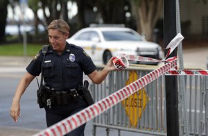 A Jacksonville police officer blocks off an area Monday, Aug. 27, 2018, near the scene of  mass shooting at Jacksonville Landing in Jacksonville, Fla.