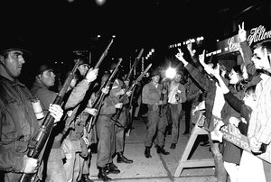 File - Peace demonstrators taunt Illinois National Guardsmen outside the Conrad Hilton, the Democratic Convention headquarters hotel, August 29, 1968. Earlier police and the demonstrators engaged in a violent clash in which hundreds were injured.