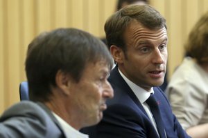 FILE - In this  Friday, July 27, 2018 file picture French President Emmanuel Macron, right, flanked with French Minister of the Ecological and Social Transition Nicolas Hulot, left, attends a summit for Energy Interconnections at the European Maritime Safety Agency headquarters in Lisbon, Portugal.