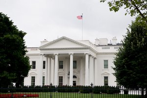 American flag at the top of White House office building during Jean-Claude Juncker trade visit in Washington