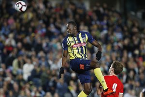 Usain Bolt goes up for a header during a friendly trial match between the Central Coast Mariners and the Central Coast Select in Gosford, Australia, Friday, Aug. 31, 2018