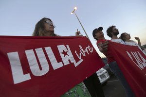 Supporters of Brazil's Former President Luiz Inacio Lula da Silva, display banners with text written in Portuguese that read "Free Lula" during during a protest in front of the Superior Electoral Court, as the trial against the candidacy of the jailed former president continues, in Brasilia, Brazil, Friday, Aug. 31, 2018.