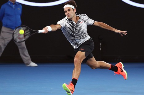 Switzerland's Stan Wawrinka makes a forehand return to compatriot Roger Federer during their semifinal at the Australian ...