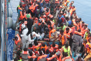 File - Irish Naval personnel from the LÉ Eithne rescuing migrants in the Mediterranean Sea north of Tripoli, Libya, from an overcrowded boat as part of Operation Triton, 15 June, 2015.