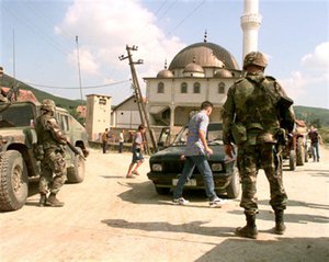 File - U.S. Army MPs from the 630th Military Police Company man a checkpoint near Vitina, Kosovo, on July 28, 1999.