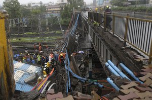 Rescue workers clear debris near the site of a broken bridge in Mumbai, India, Tuesday, July 3, 2018 . (AP Photo/Rafiq Maqbool)