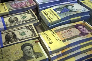 In this Saturday, April 4, 2015 photo, Iranian and U.S. banknotes are on display at a currency exchange shop in downtown Tehran, Iran.