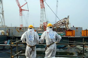 File - Two IAEA experts examine recovery work on top of Unit 4 of TEPCO's Fukushima Daiichi Nuclear Power Station on 17 April 2013 as part of a mission to review Japan's plans to decommission the facility.