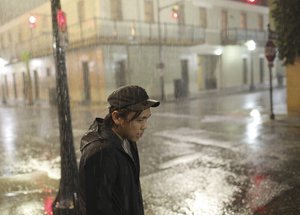 Charles Phanthapannha stands in the rain outside a bar as Tropical Storm Gordon approaches on Tuesday, Sept. 4, 2018 in Mobile, Ala.