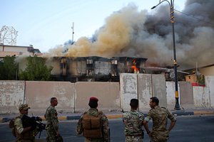 Security forces are watch the burning provincial government building during anti-government protests in Basra, 340 miles (550 km) southeast of Baghdad, Iraq, Thursday, Sept. 6, 2018.