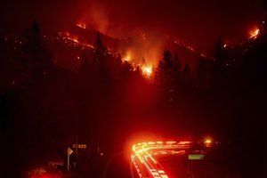 Fire trucks pass the Delta Fire burning in the Shasta-Trinity National Forest, Calif., on Wednesday, Sept. 5, 2018.