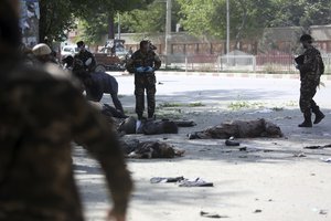 A victim of a second blast lie on the ground in Kabul, Afghanistan, Monday, April 30, 2018. A coordinated double suicide bombing hit central Kabul on Monday morning.