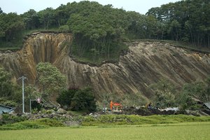 Police search missing persons at the site of a landslide triggered by an earthquake in Atsuma town, Hokkaido, northern Japan, Friday, Sept. 7, 2018.