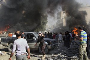 File - This photo provided by the Syrian Civil Defense White Helmets, which has been authenticated based on its contents and other AP reporting, shows Civil Defense workers and Syrian citizens gathering after an airstrike hit a market in Maaret al-Numan in southern Idlib, Syria, Sunday, Oct. 8, 2017.