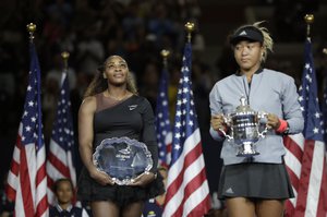 Serena Williams watches as Naomi Osaka, of Japan, holds the champions trophy in the women's final of the U.S. Open tennis tournament, Saturday, Sept. 8, 2018, in New York.