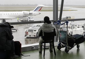 In this Dec.17, 2011 file photo, a passenger waits for his flight during a strike at Lyon-Saint Exupery airport, central France.