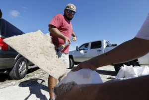 Walker Townsend, at left, from the Isle of Palms, S.C., fills a sand bag while Dalton Trout, at right, holds the bag at the Isle of Palms municipal lot where the city was giving away free sand in preparation for Hurricane Florence at the Isle of Palms S.C., Monday, Sept. 10, 2018.