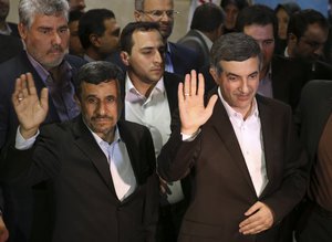 In this picture taken on Saturday, May 11, 2013, Iranian President Mahmoud Ahmadinejad, left, and his close ally Esfandiar Rahim Mashaei wave to journalists as they arrive at the election headquarters of the interior ministry for registering Masheaei's candidacy for the upcoming presidential election, in Tehran, Iran