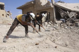 This photo released on Monday, Sept. 10, 2018 by the Syrian Civil Defense group known as the White Helmets, shows civil defense workers clean rubble from a house which was damaged by a Syrian government airstrike, in Hobeit village, near Idlib, Syria.