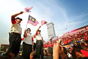 File - Najib Razak and his wife Rosmah, with the deputy prime minister Muhyiddin (from left to right) waving flags during Malaysia day celebration at Merdeka Square, Kuala Lumpur, 16 September 2011.