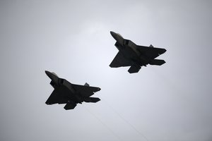 Two U.S. Air Force F-22 fighter jets perform a flyover during the playing of the national anthem before a NASCAR Cup Series auto race at Daytona International Speedway, Saturday, July 7, 2018, in Daytona Beach, Fla.