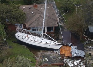 A sailboat is shoved up against a house and a collapsed garage Saturday, Sept. 15, 2018, after heavy wind and rain from Florence, now a tropical storm, blew through New Bern, N.C.