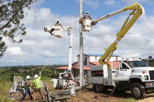 File - Despite the rugged terrain, power workers with the U.S. Army Corps of Engineers reconnect power lines near the town of Lares, Puerto Rico, Jan. 24, 2018. An estimated 80 percent of the power grid in Puerto Rico was destroyed by Hurricane Maria in September.