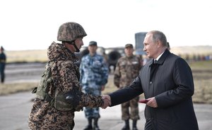 Russian President Vladimir Putin, right, shakes hands with a Chinese serviceman during Vostok-2018 military manoeuvres