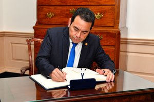 Guatemalan President Jimmy Morales signs U.S. Secretary of State Rex Tillerson's guestbook before their bilateral meeting at the U.S. Department of State in Washington, D.C., on February 8, 2018