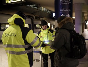 Security staff check the ID of a passenger at the train station Copenhagen International Airport in Kastrup to prevent illegal migrants entering Sweden on Monday Jan. 4, 2016.