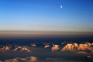 File - The moon just over the horizon seen from the NASA P-3 over northeast Greenland during an IceBridge survey flight on Mar. 12, 2014.