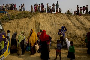 Rohingya Muslims watch from atop a hill as new refugees arrive in Balukhali refugee camp, 50 kilometres (32 miles) from Cox's Bazar, Bangladesh, Sunday, Jan. 14, 2018.