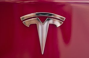 In this Aug. 8, 2018, file photo a Tesla emblem is seen on the back end of a Model S in the Tesla showroom in Santa Monica, Calif