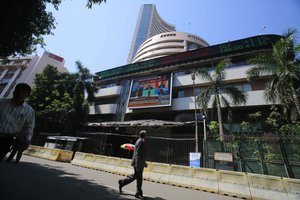 A man watches sensex on a display screen on the facade of the the Bombay Stock Exchange (BSE) building in Mumbai , India, Monday Feb. 17, 2014.