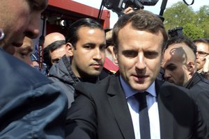 In this Wednesday April 26, 2017 file photo, Emmanuel Macron, right, is flanked by his bodyguard, Alexandre Benalla, left background, outside the Whirlpool home appliance factory, in Amiens, northern France.