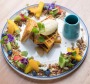 Spiced pumpkin waffle encircled by fruit, nuts and seeds.