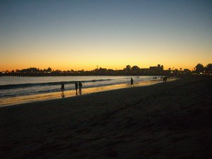 File - Sun sets on the wharf and the city skyline, Santa Cruz, California.