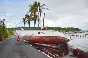 File - A boat damaged by Hurricane Maria partially blocks a road in Fajardo, Puerto Rico, Oct. 28, 2017.