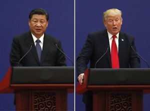 In this combination of Nov. 9, 2017 photos, U.S. President Donald Trump, right, and Chinese President Xi Jinping speak during a business event at the Great Hall of the People in Beijing.