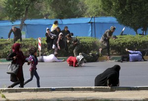 In this photo provided by Mehr News Agency, civilians try to take shelter in a shooting scene, during a military parade marking the 38th anniversary of Iraq's 1980 invasion of Iran, in the southwestern city of Ahvaz, Iran, Saturday, Sept. 22, 2018.