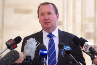 Joe Francis in front of media microphones outside Parliament House