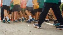 The legs of a group of school children dressed in uniforms. 