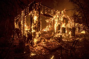 Flames consume a home as a wildfire burns in Ojai, California, on Thursday, Dec. 7, 2017.