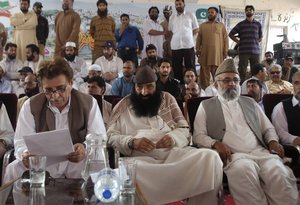 Prime Minister of Pakistan held Kashmir Raja Farooq Haider Khan, left, attends a rally organized by Kashmiri militants groups with Syed Salahuddin, center, the head of Kashmiri militant group Hizbul Mujahideen, and Rasheed Turabi in Muzaffarabad, capital of Pakistani Kashmir on Tuesday, July 13, 2010.