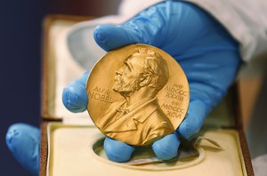 FILE- In this file photo dated Friday, April 17, 2015, a national library employee shows the gold Nobel Prize medal awarded to the late novelist Gabriel Garcia Marquez, in Bogota, Colombia.