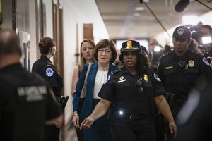 Sen. Susan Collins, R-Maine, is escorted by U.S. Capitol Police past waiting reporters trying to ask about Supreme Court nominee Brett Kavanaugh, on Capitol Hill in Washington, Wednesday, Oct. 3, 2018.